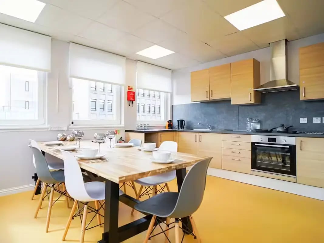 Dining table chairs kitchen cabinets and oven kitchen at 8 Roxburgh in Edinburgh Student Accommodation