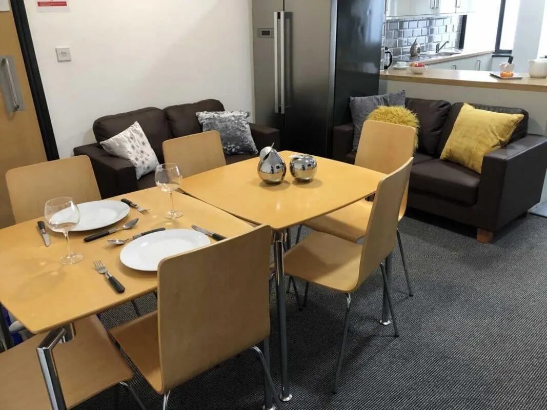 Dining table with plates cutlery sofas living area at Mandale Terrace in Stockton-On-Tees Student Accommodation