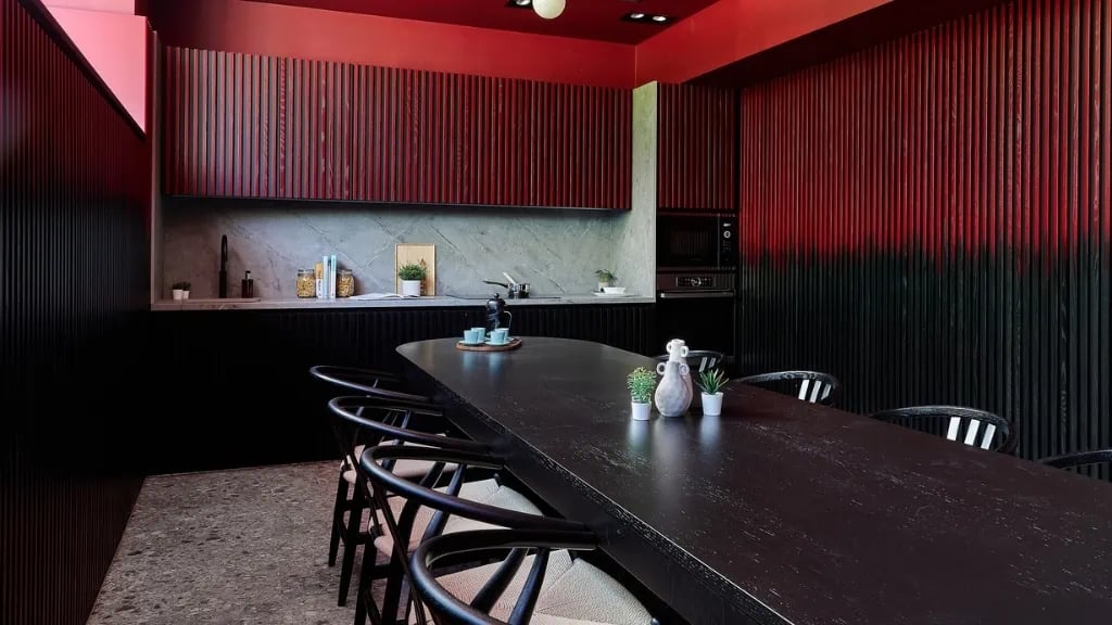 Dark dining table with chairs communal kitchen at The Helix in London Student Accommodation