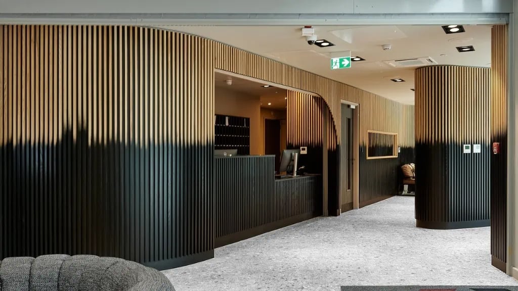 Reception desk with wooden slats and seating area entrance at The Helix in London Student Accommodation