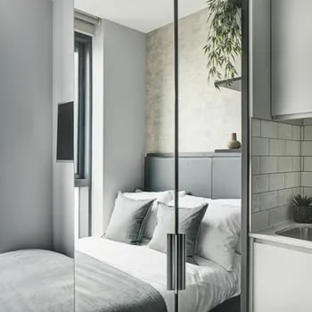Bed pillows grey throw rug bedroom at ARK Canary Wharf in London Student Accommodation