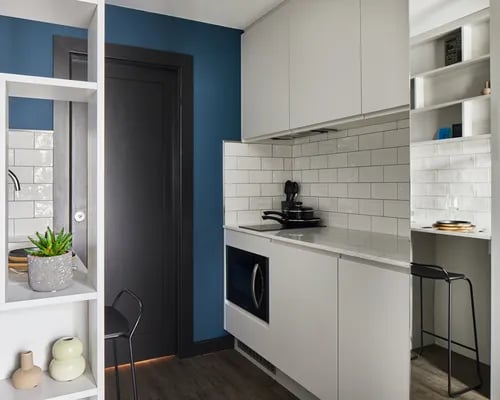 Modern white cabinets microwave oven and stool kitchen at ARK Canary Wharf in London Student Accommodation