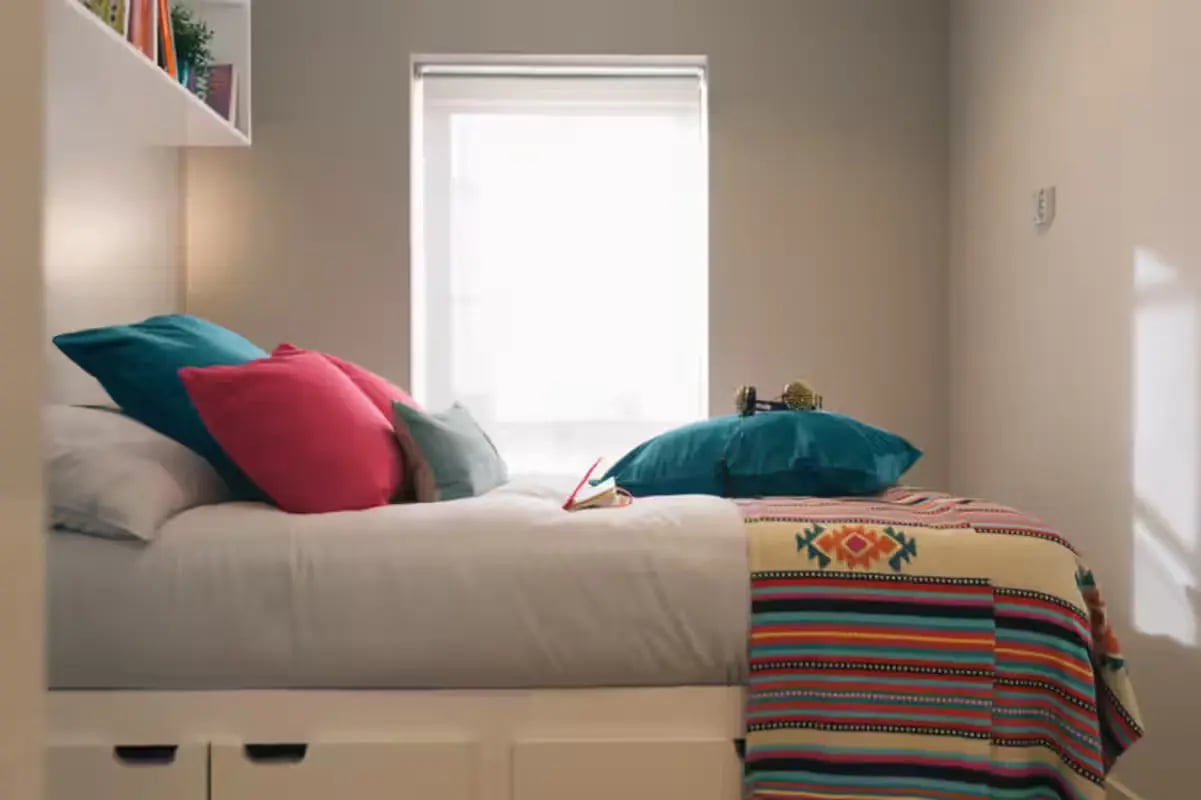 Bed with colorful pillows and blanket bedroom at Clifton Place in Exeter Student Accommodation