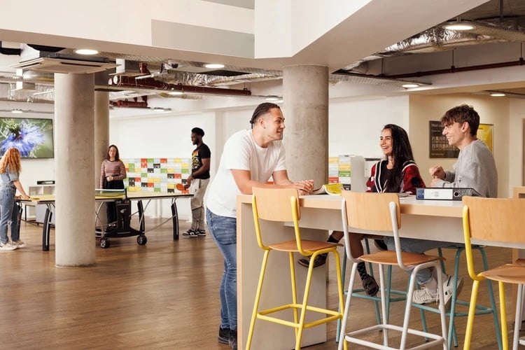 Students play ping pong and chat at communal table Communal area at St Lukes View in Liverpool Student Accommodation