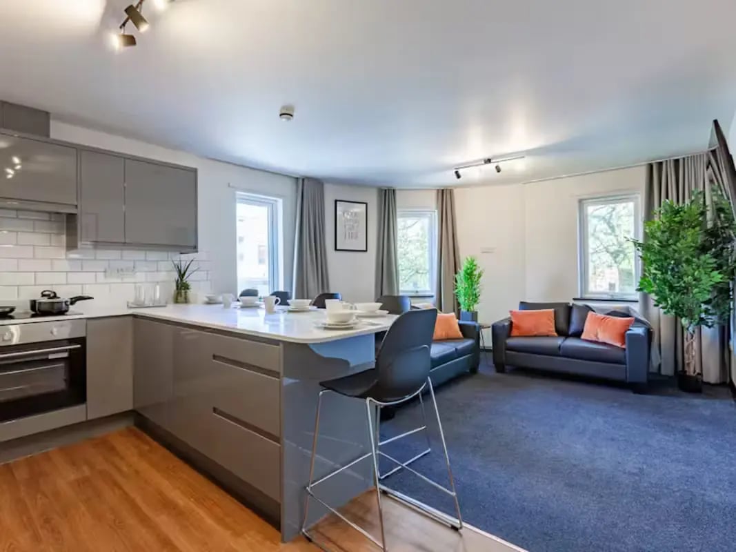 Modern kitchen island with stools and sofas living room at Trinity Student Village in Preston Student Accommodation