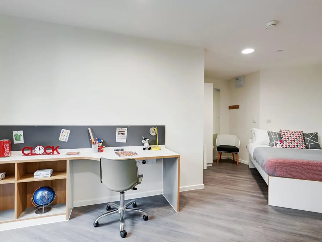 Desk chair bed and pillows student room at New Bridewell in Bristol Student Accommodation