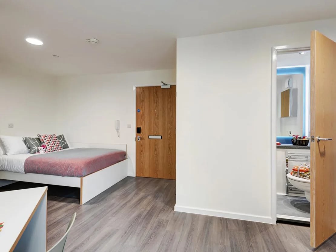 Bed desk and bathroom visible studio apartment at New Bridewell in Bristol Student Accommodation