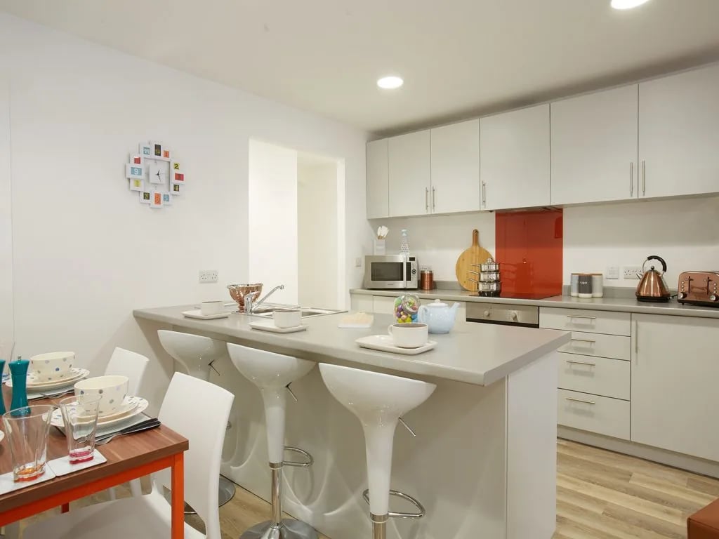 Dining table stools island sink cabinets kitchen at The Shield in Newcastle Upon Tyne Student Accommodation