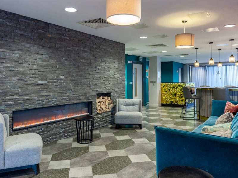 Modern lounge with fireplace sofas and bar area at The Fitzalan in Cardiff Student Accommodation