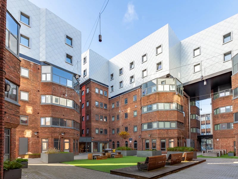 Courtyard with brick buildings and seating Exterior at The Fitzalan in Cardiff Student Accommodation