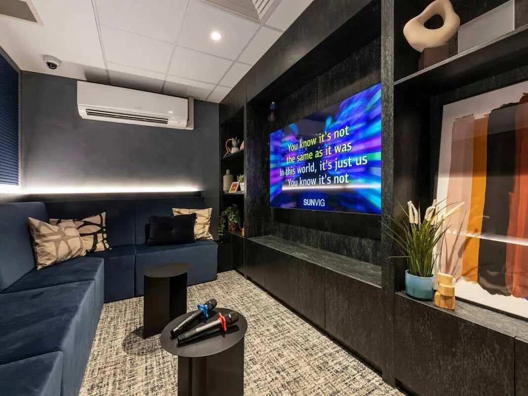 Blue sofa television microphones air conditioning entertainment room at Alma Place in Belfast Student Accommodation