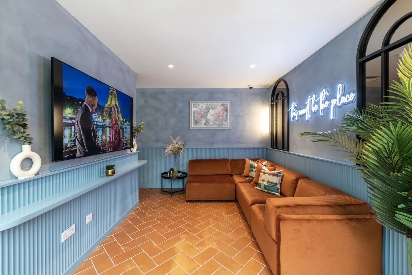 Velvet sectional sofa neon sign living room at Aster House in Belfast Student Accommodation