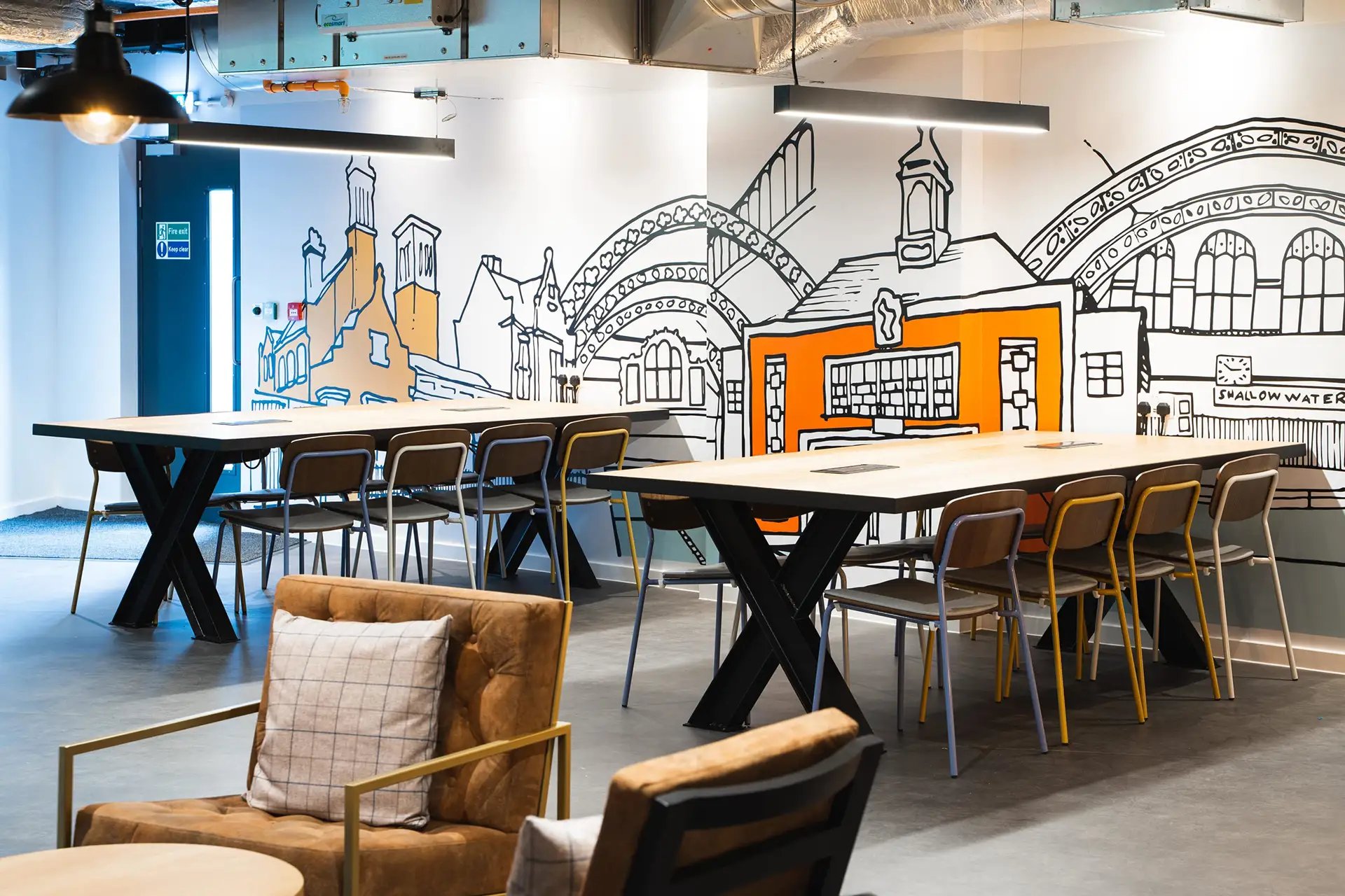 Tables chairs with artwork in student accommodation common area at Altura Birmingham in Birmingham Student Accommodation