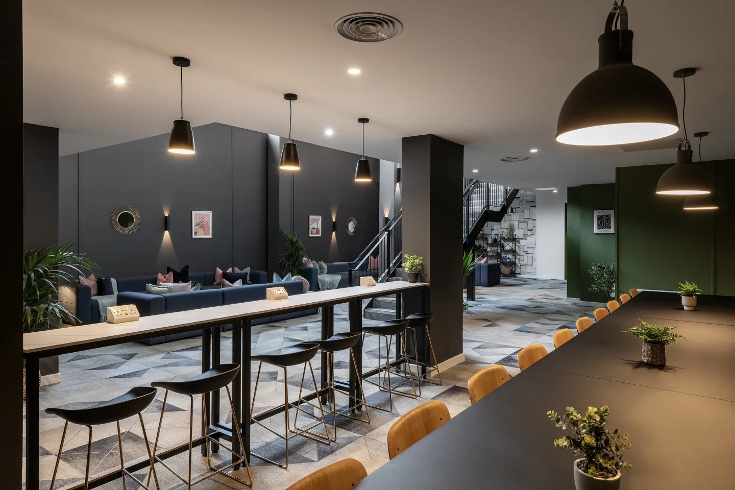 Long table with stools and lounge seating living room at Infinity Coventry in Coventry Student Accommodation