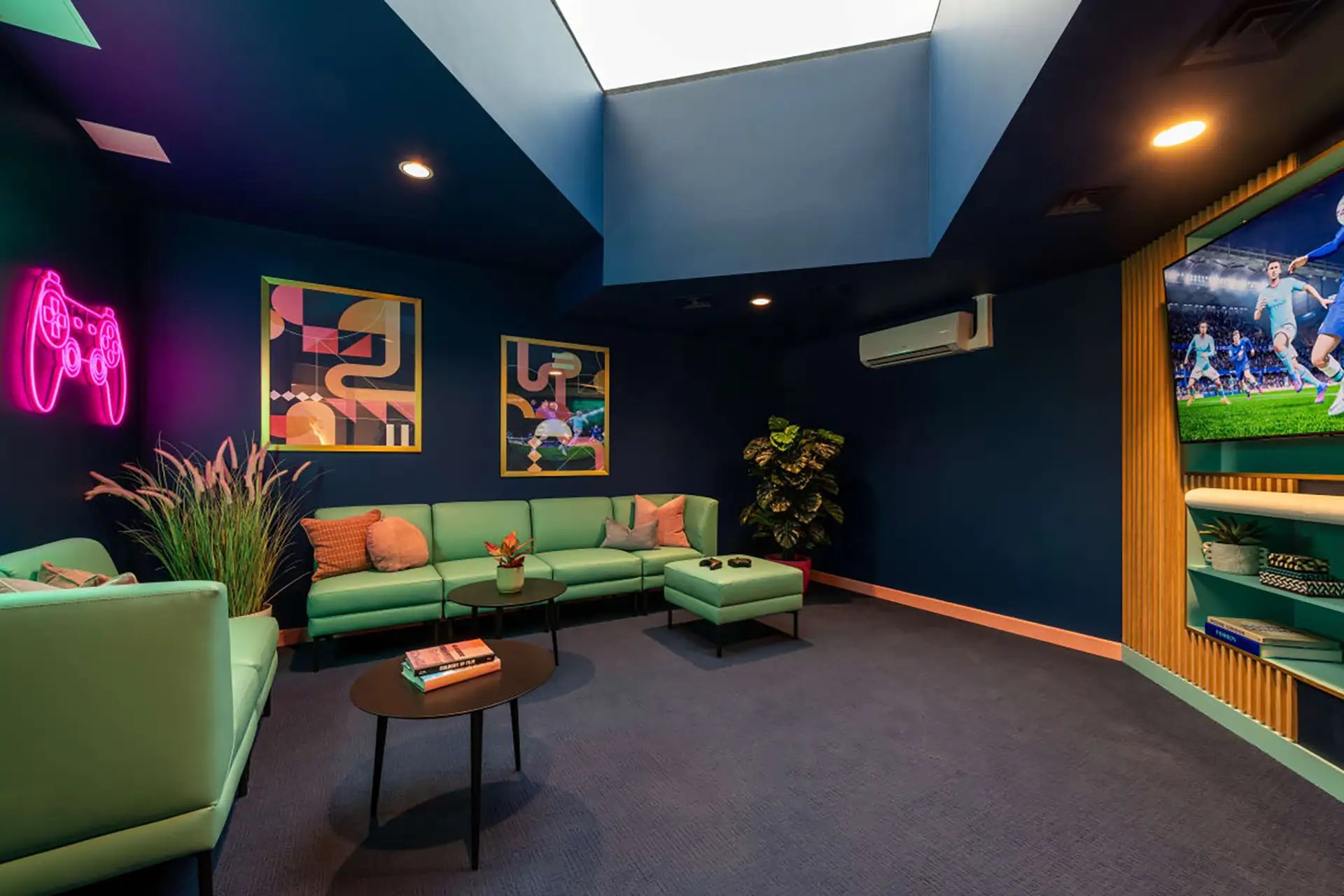 Green sofas gaming neon art TV living room at Wick Park in London Student Accommodation