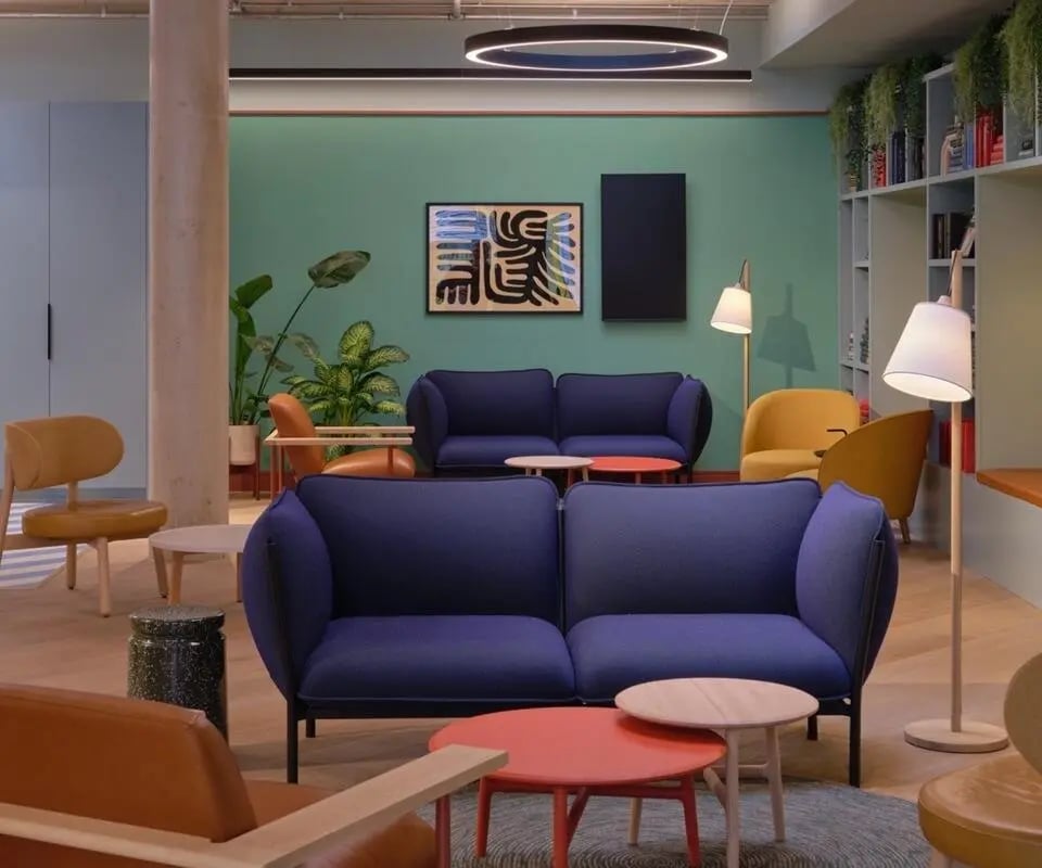 Blue sofas yellow chairs coffee tables living room at Scape Canada Water in London Student Accommodation