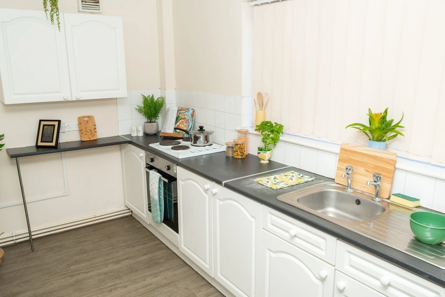 White cabinets stove sink and plants kitchen at Grange Court & The Ridings in Ormskirk Student Accommodation