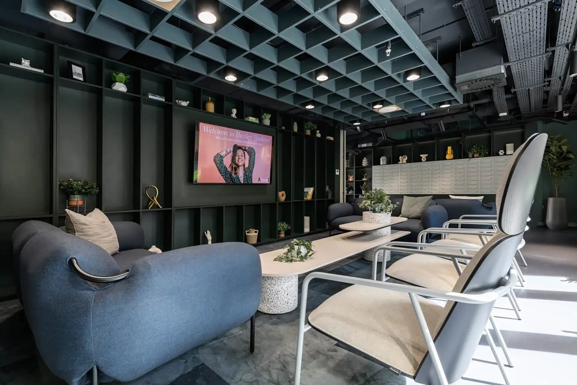 Modern communal lounge with sofas tables and chairs. at Huxley Studios in Edinburgh Student Accommodation
