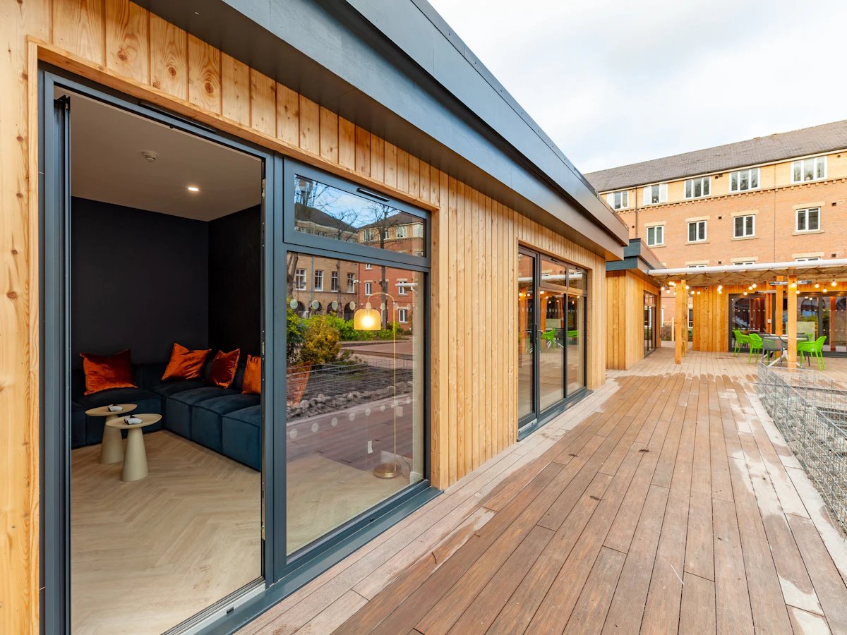 Sectional couch with orange cushions outdoor seating area at The Leather Works in Leeds Student Accommodation