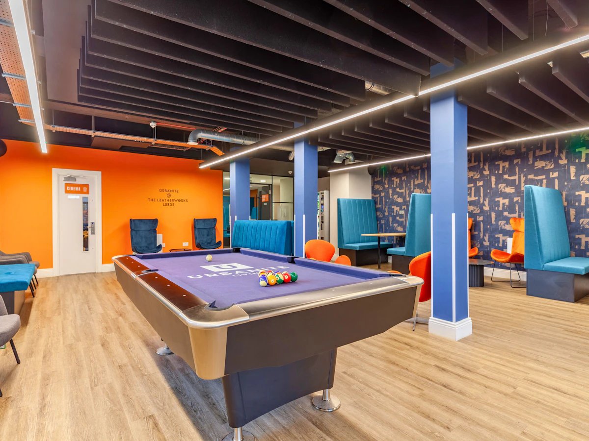 Pool table blue booths orange chairs lounge area at The Leather Works in Leeds Student Accommodation