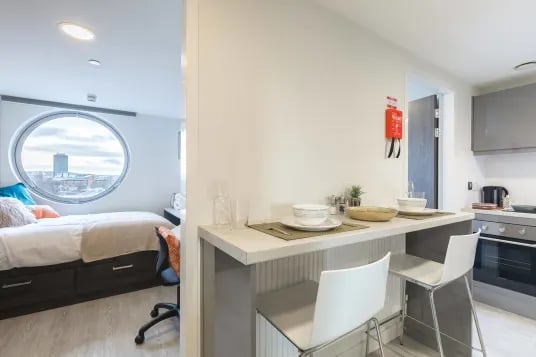Bed kitchen counter with stools dining area bedroom at Livin Cardiff in Cardiff Student Accommodation