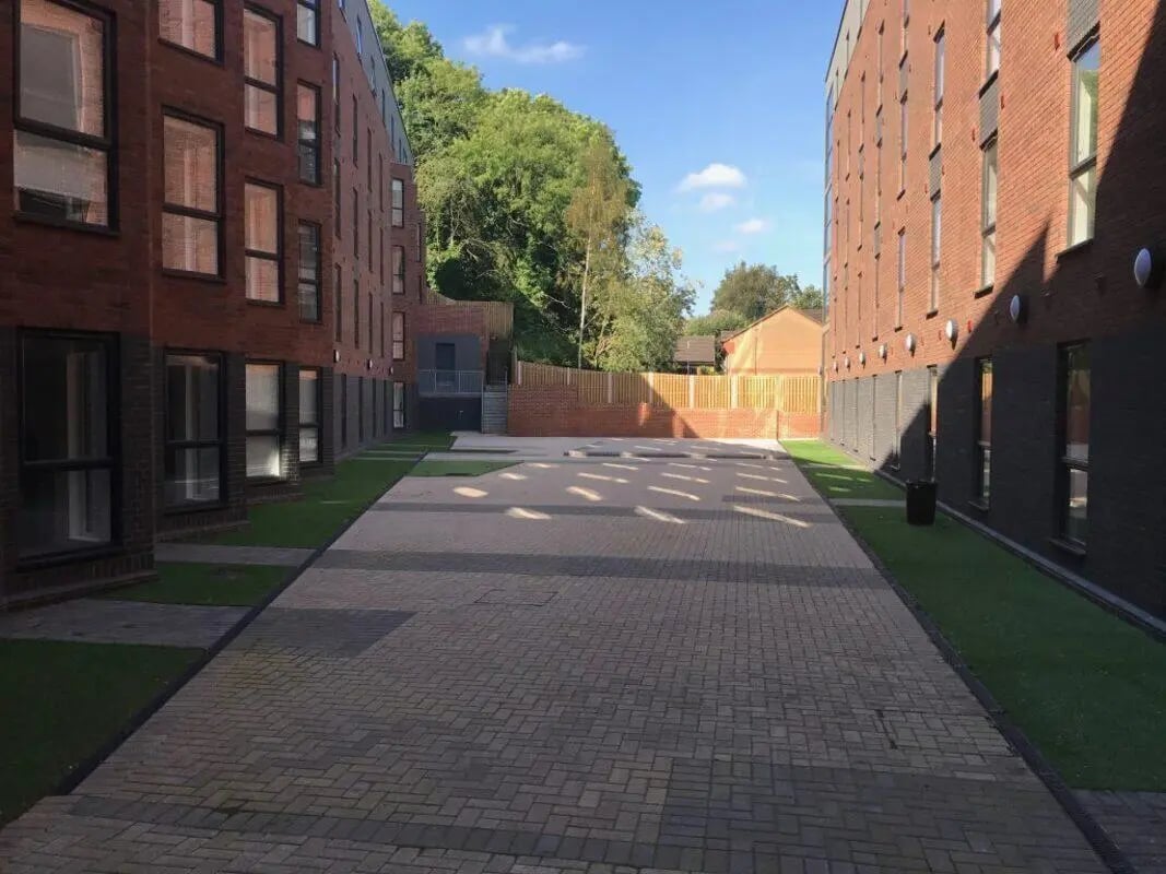 Brick buildings green grass paved courtyard exterior at Q Studios in Stoke-On-Trent Student Accommodation