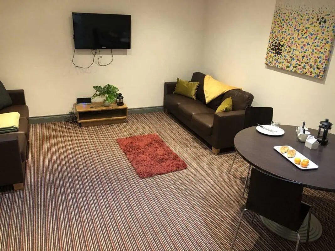 Brown sofa TV colorful art striped carpet living room at Norflok Street in Sunderland Student Accommodation