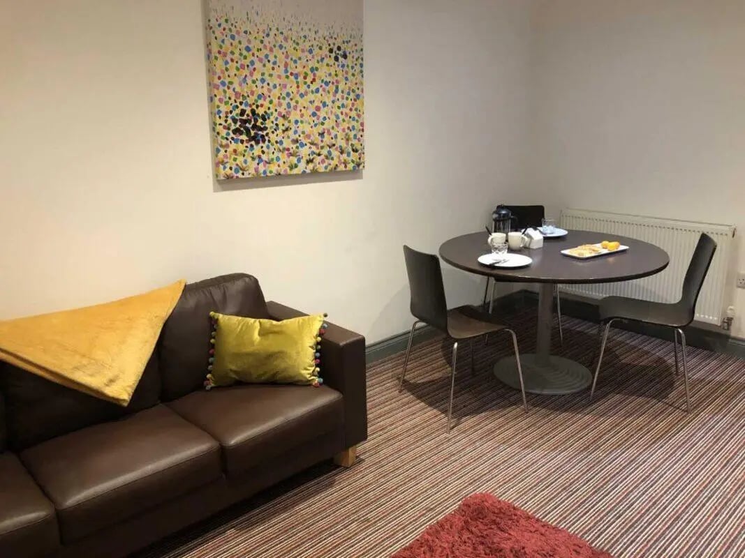 Brown sofa artwork table chairs living room at Norflok Street in Sunderland Student Accommodation