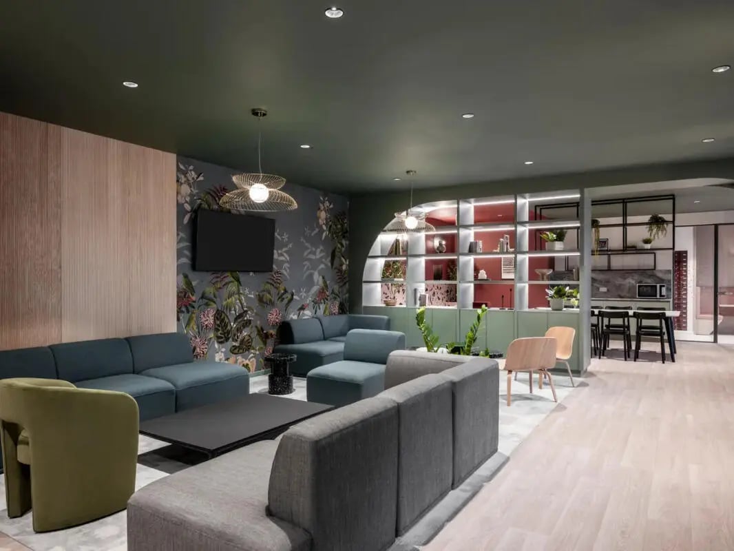 Sofas tables shelves and kitchen living room at Dunaskin Mill in Glasgow Student Accommodation