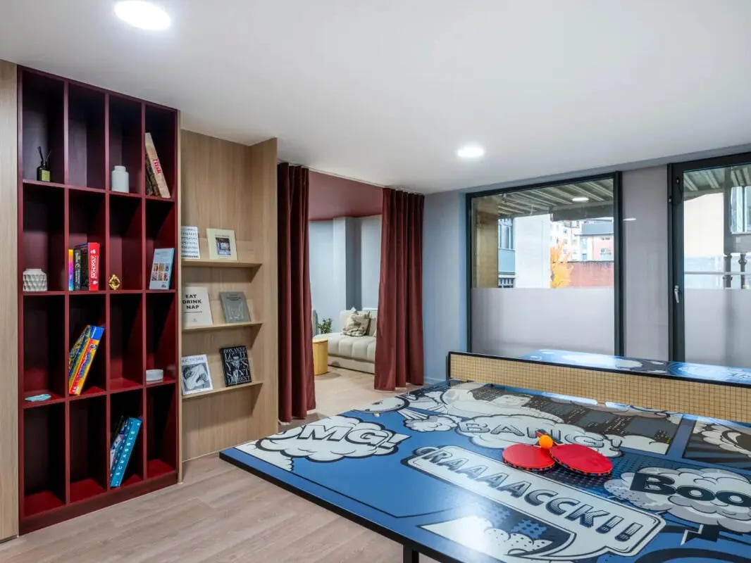 Bookshelf ping pong table with paddles and balls common area at Dunaskin Mill in Glasgow Student Accommodation