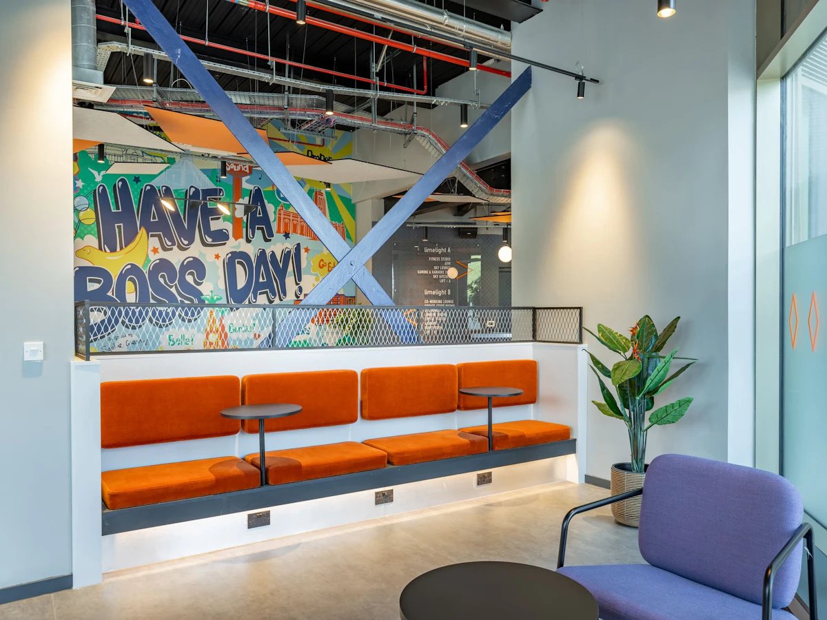 Orange seating colorful wall art and purple chair lounge area at Limelight in Liverpool Student Accommodation