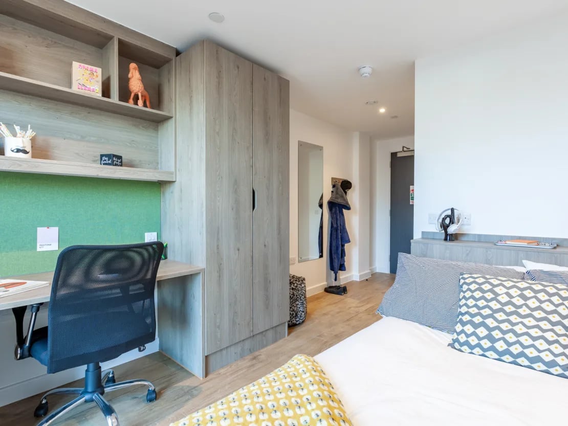 Desk chair wardrobe bed and pillows bedroom at Pavilion Point in Brighton Student Accommodation