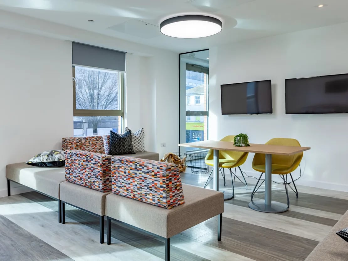 Sofa table chairs televisions living room at Pavilion Point in Brighton Student Accommodation