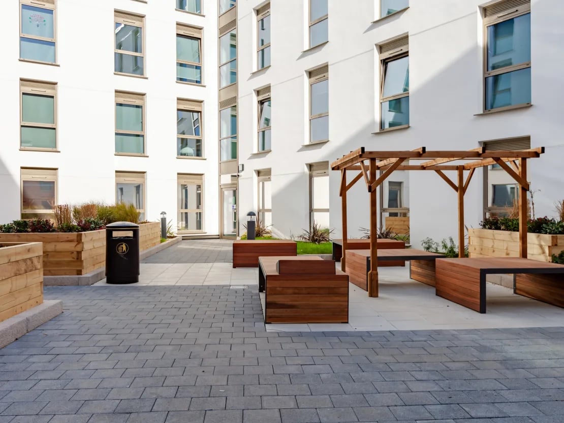 Modern outdoor seating area with wooden pergola exterior at Pavilion Point in Brighton Student Accommodation