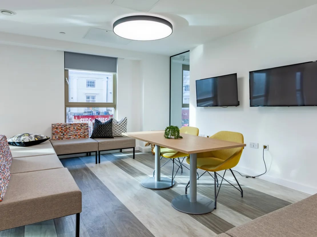 Lounge area with couches table chairs and TVs living room at Pavilion Point in Brighton Student Accommodation