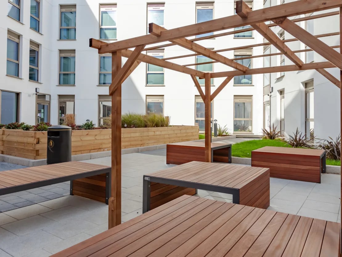 Wooden seating and planters courtyard exterior at Pavilion Point in Brighton Student Accommodation
