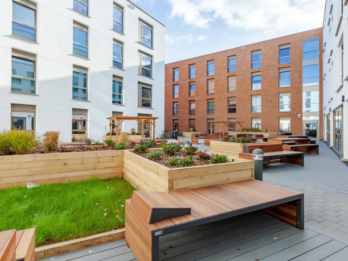 Modern apartment buildings with outdoor seating and planters exterior at Pavilion Point in Brighton Student Accommodation