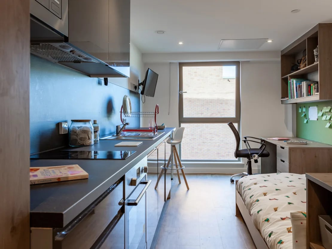 Kitchenette desk chair bed and window view living room at Pavilion Point in Brighton Student Accommodation