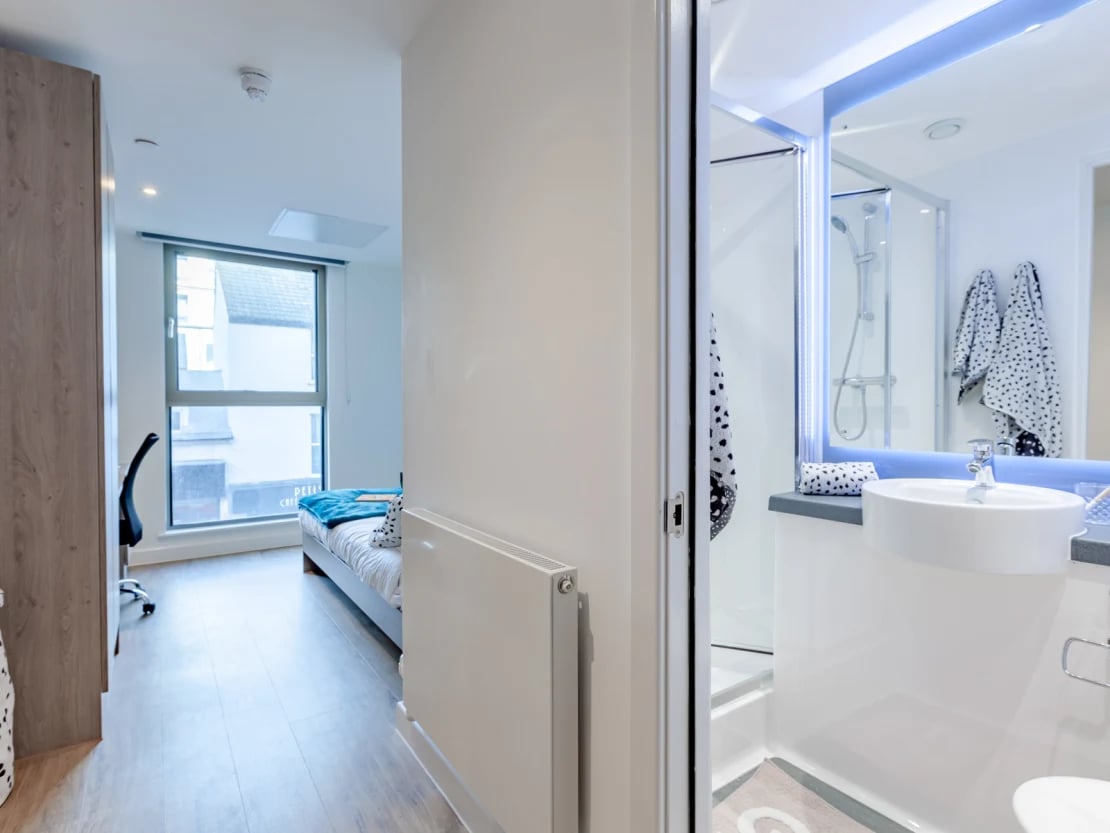Bed desk radiator and modern bathroom interior at Pavilion Point in Brighton Student Accommodation