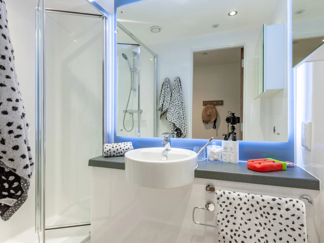 Shower sink mirror towels and toiletries bathroom at Pavilion Point in Brighton Student Accommodation