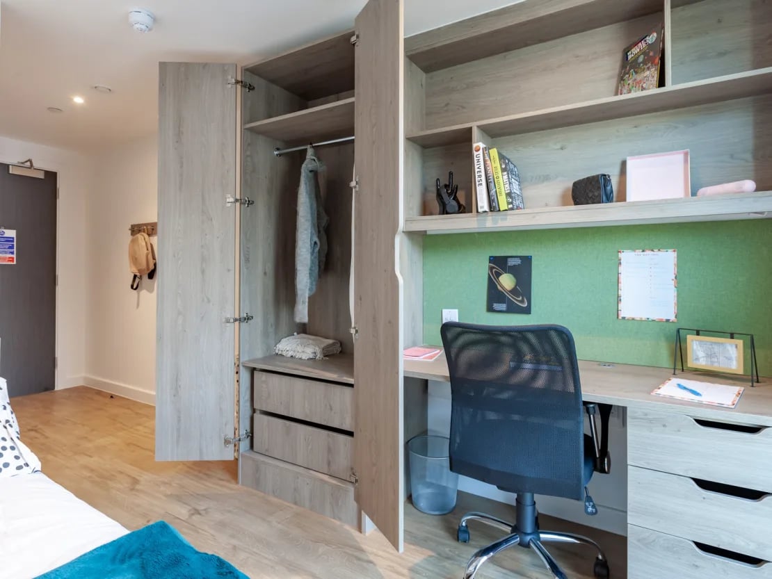 Wardrobe desk chair books and noticeboard study area at Pavilion Point in Brighton Student Accommodation