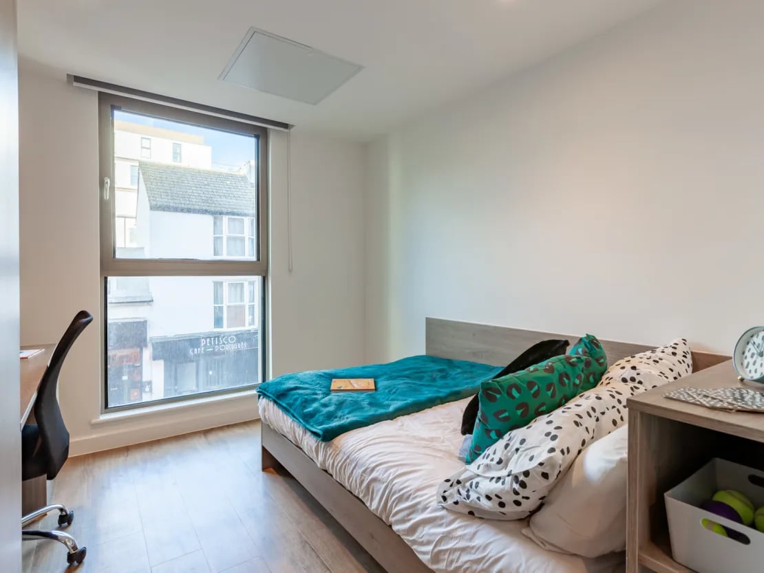 Bed desk chair and pillows bedroom at Pavilion Point in Brighton Student Accommodation