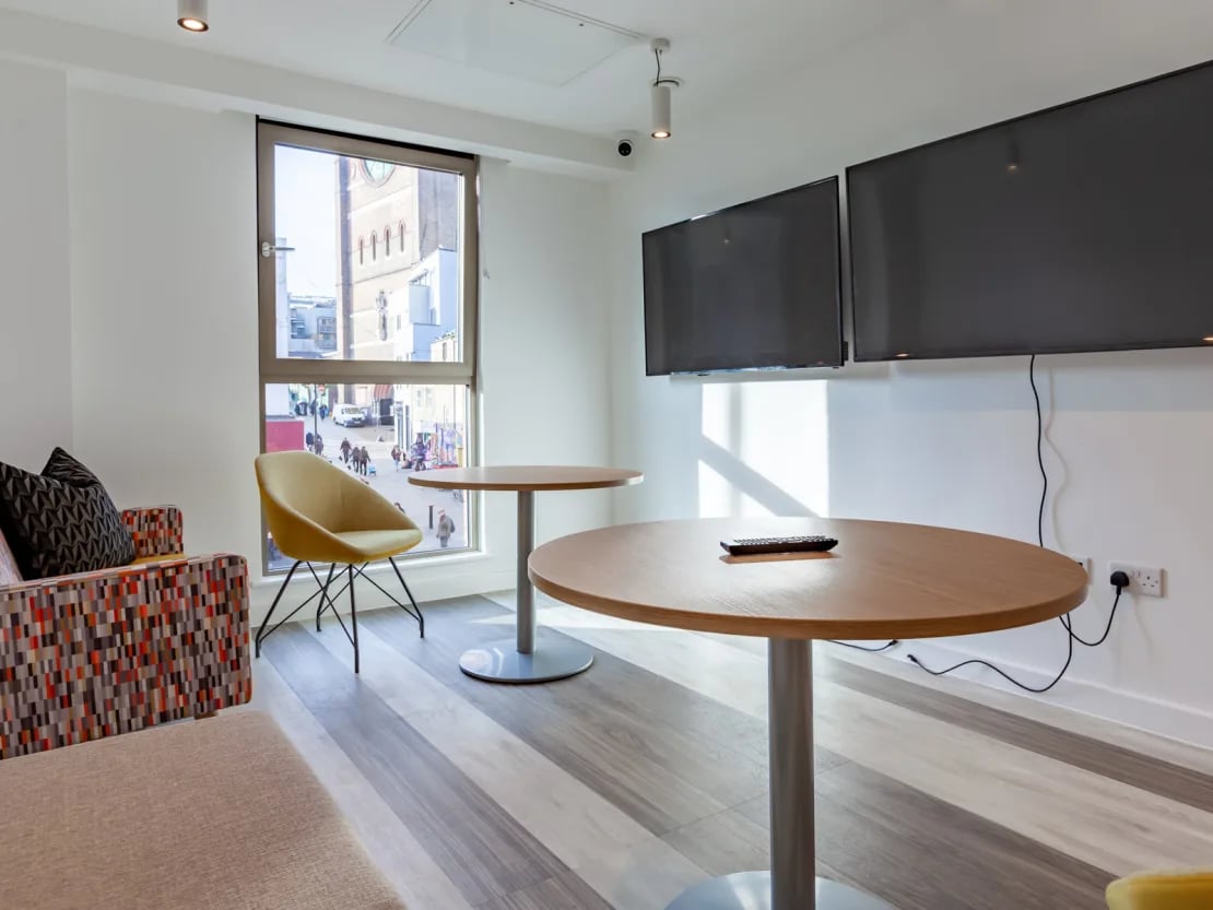 Sofa tables chairs and TVs common area at Pavilion Point in Brighton Student Accommodation