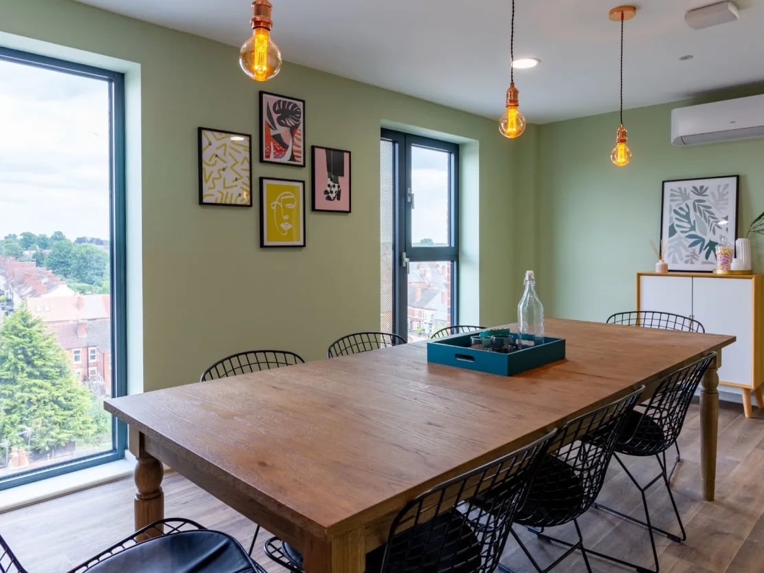 Wooden dining table black chairs framed art dining area at Gulson Gardens in Coventry Student Accommodation