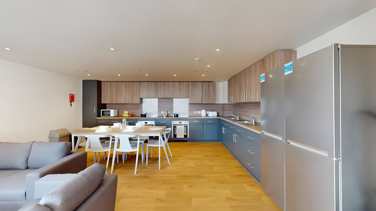 Sofa dining table kitchen appliances two fridges kitchen at Innovo House in Liverpool Student Accommodation