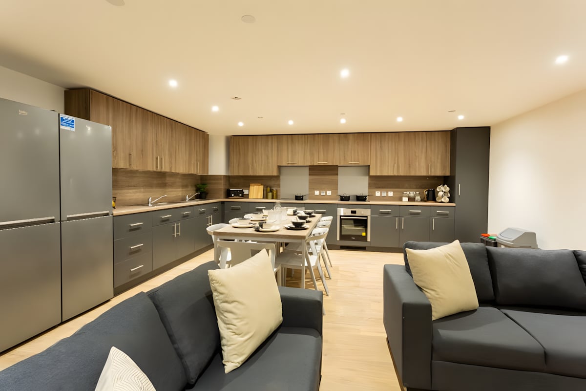 Sofa dining table and kitchen with fridges living room at Innovo House in Liverpool Student Accommodation