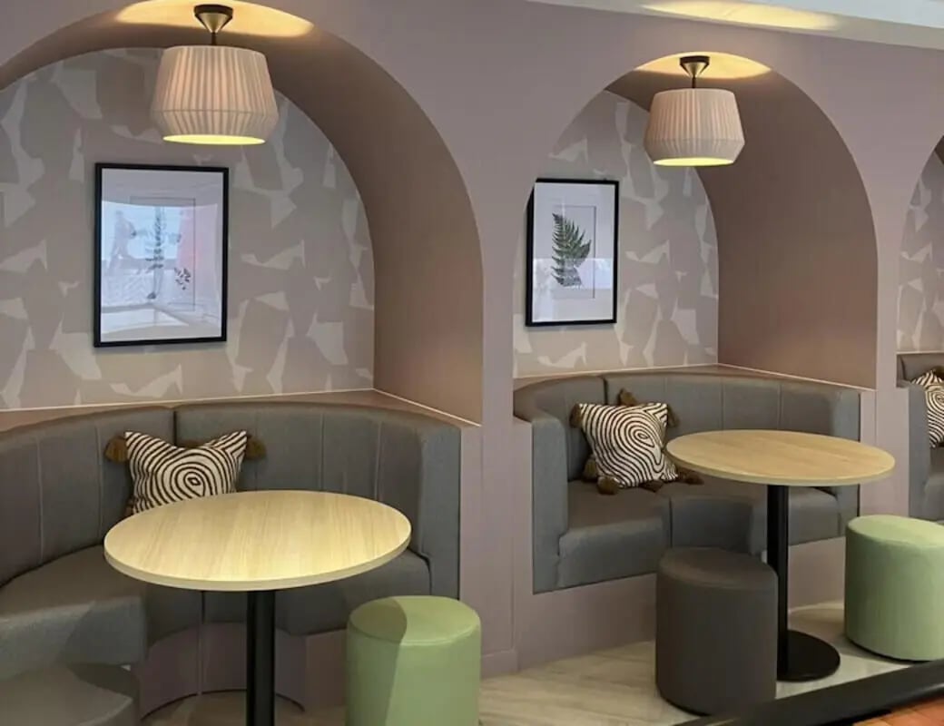 Booth seating tables with artwork and lamps common area at Byrom Point in Liverpool Student Accommodation
