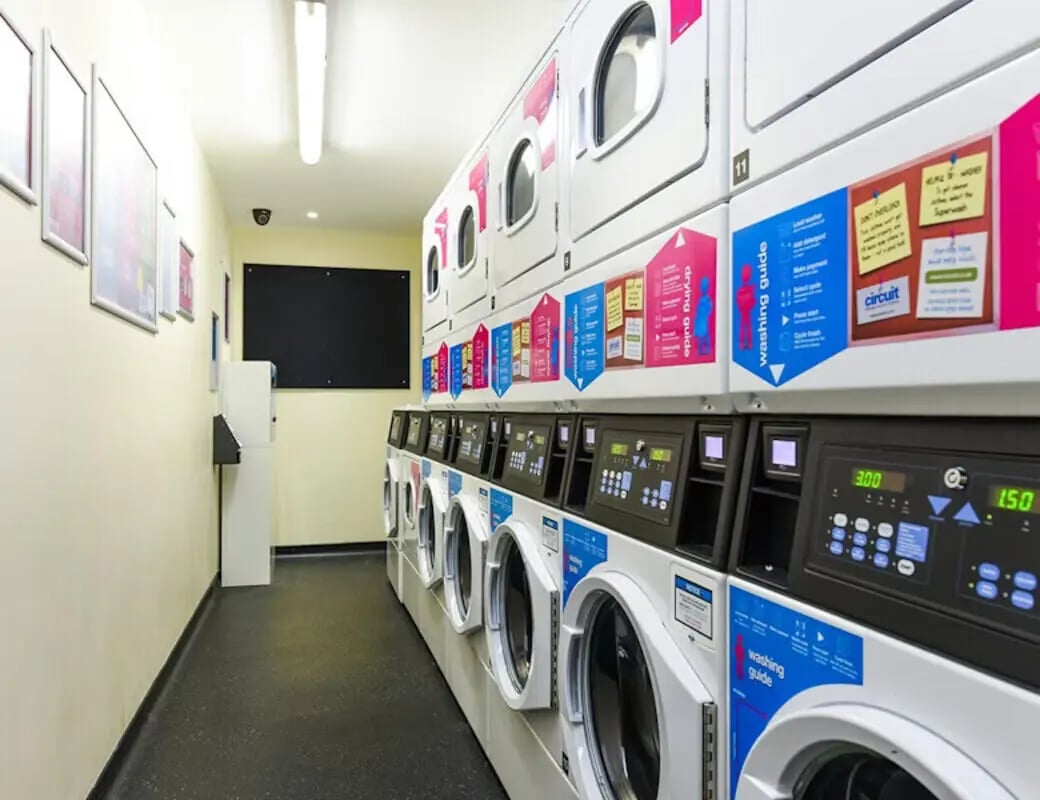 Row of washing machines and dryers laundry room at Byrom Point in Liverpool Student Accommodation