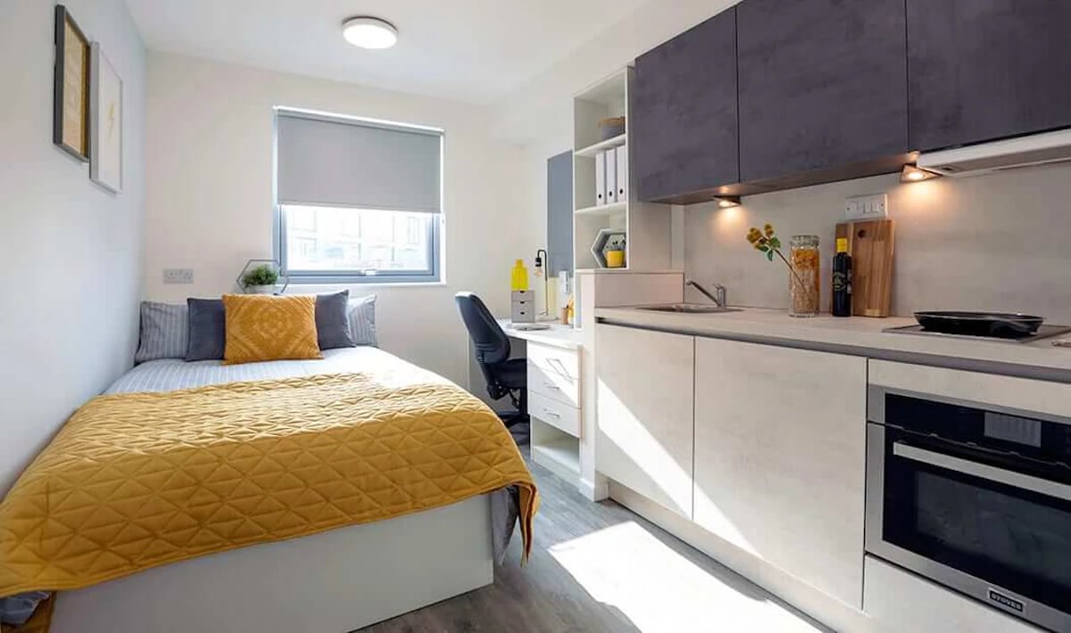 Bed desk kitchen area and oven kitchen at Westcombe House in London Student Accommodation