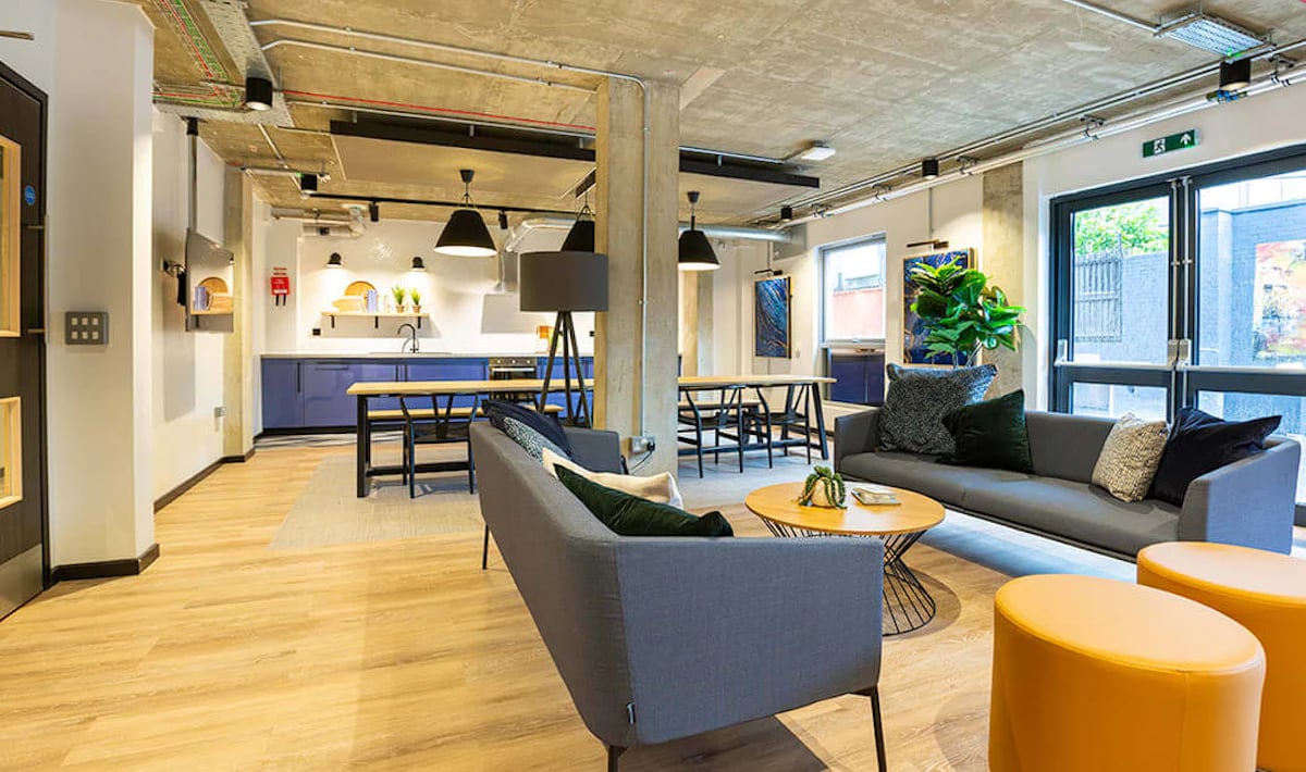 Sofa coffee table kitchen dining tables common area at Westcombe House in London Student Accommodation